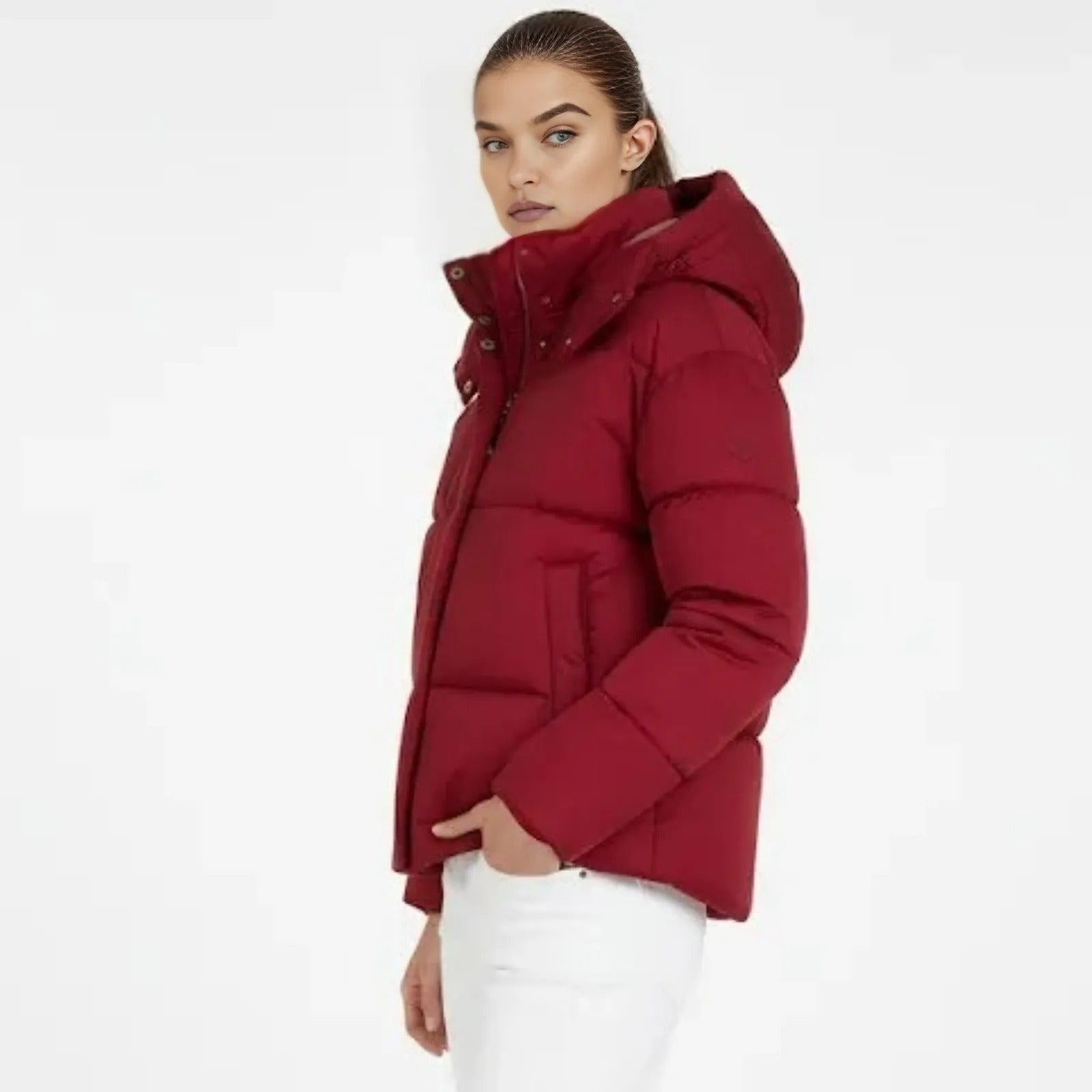 Side profile of a model in the crimson red Miranda puffer jacket by Kouvr Fashion, showing the boxy fit and insulated hood.