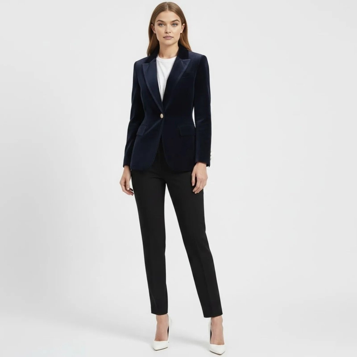 Woman wearing the Kouvr Fashion navy blue velvet blazer with a white t-shirt and black tailored trousers, standing front-on.