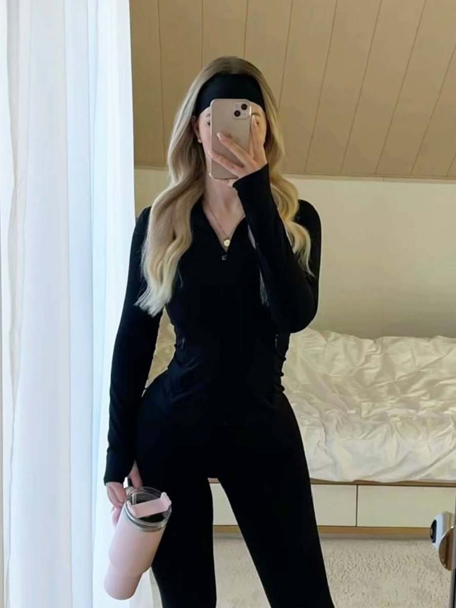 Woman wearing a black headband and the black Kouvr Nola Sculpt Jacket, showing a full workout outfit in a bedroom mirror selfie.