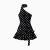 Flatlay studio shot of a black and white polka dot one-shoulder mini dress showcasing the choker neck and ruffle details.