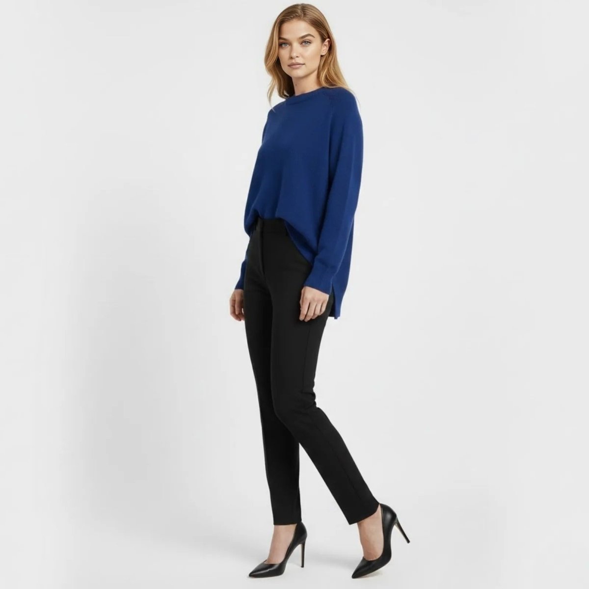 Model in a side profile view showcasing the relaxed drape and high-low hem of the Kouvr Fashion oversized cobalt blue sweater.