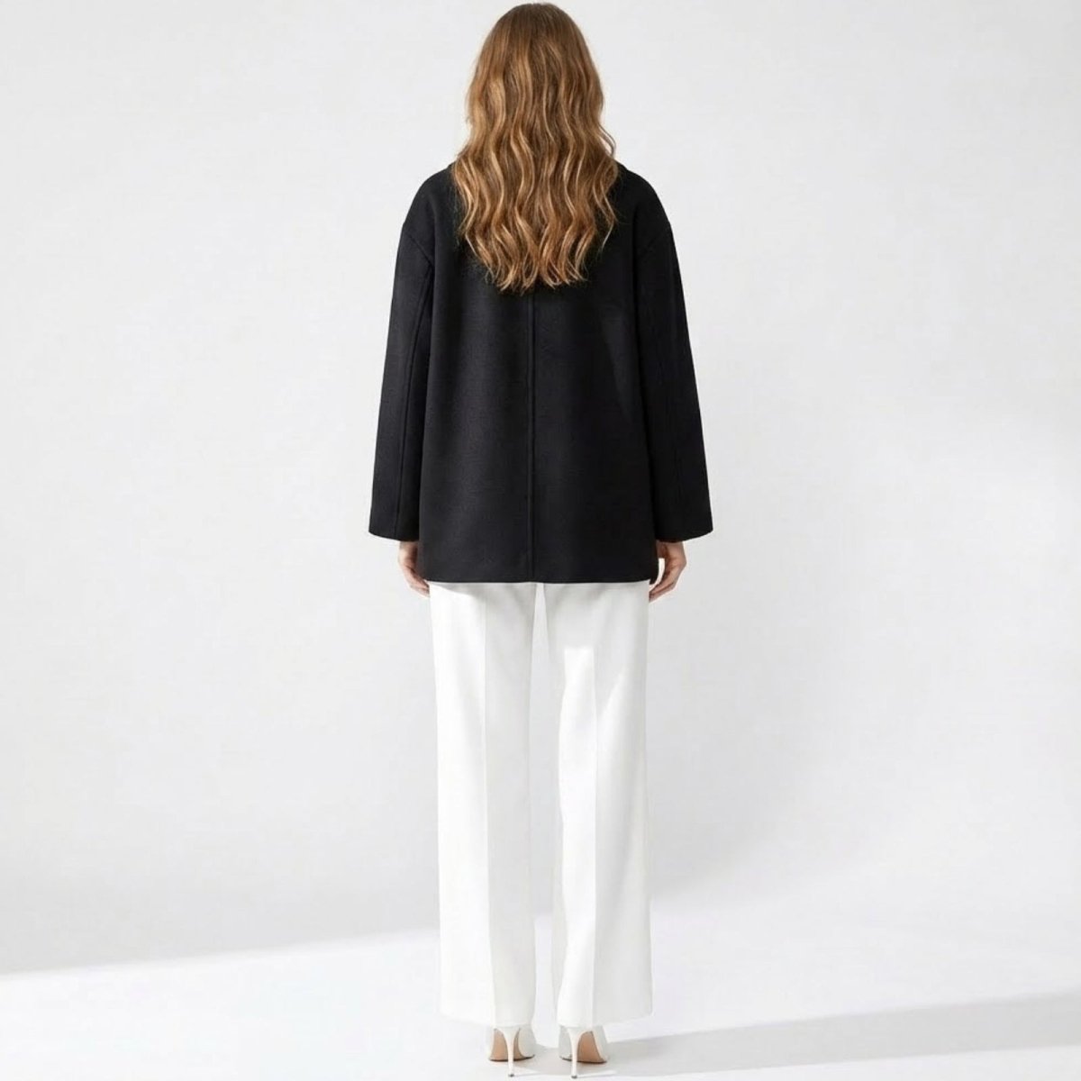 Back view of a model wearing the Kouvr Fashion oversized black wool peacoat, highlighting its clean lines and minimalist design.