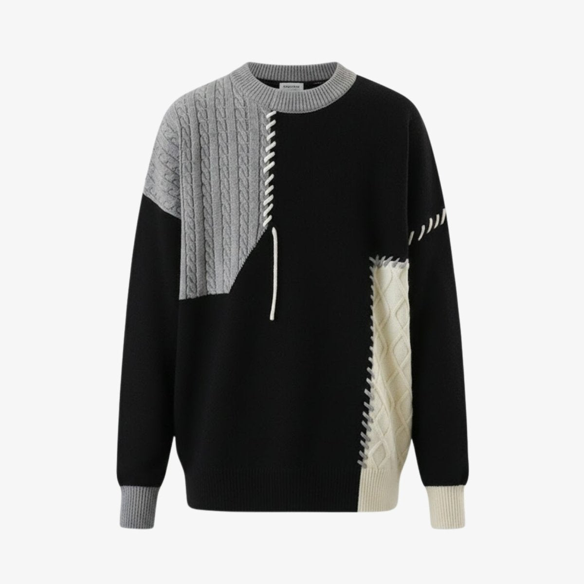 Product flatlay of the Kouvr Fashion men's sweater showing the full asymmetrical patchwork design with cable knit and chunky stitch details.