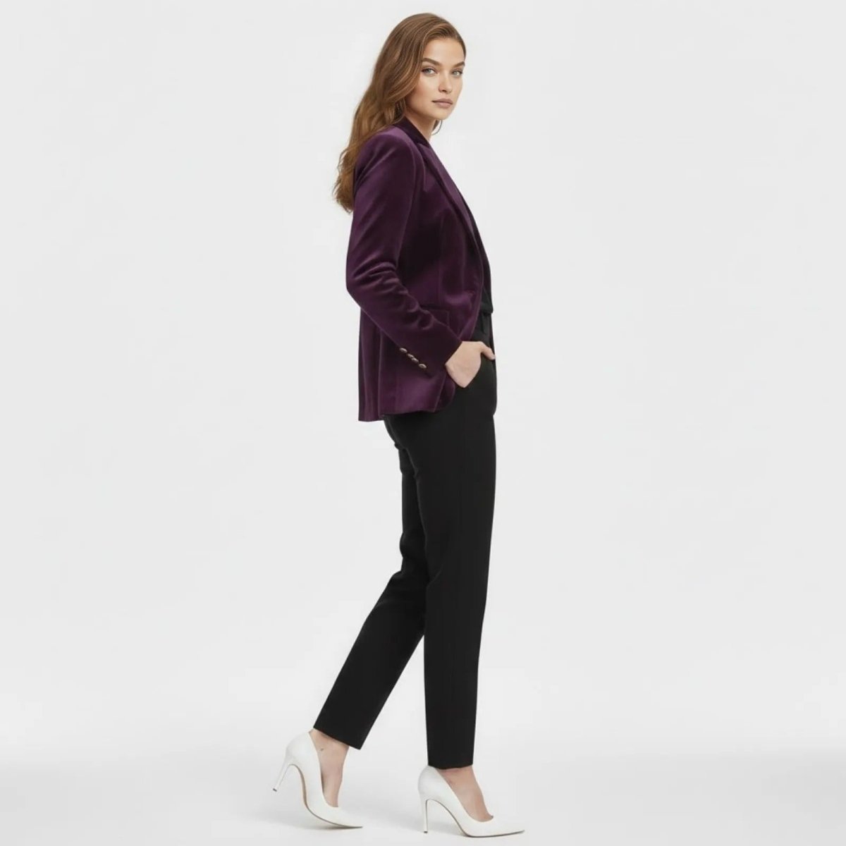 Side profile of a model wearing the tailored purple velvet blazer, showing the fit and sleeve detail with gold buttons.