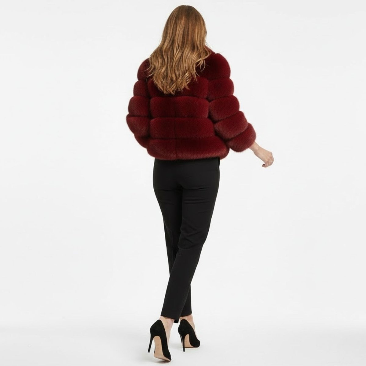 Back view of a woman wearing a short crimson red faux fur jacket, showcasing the horizontal panel design and fit.