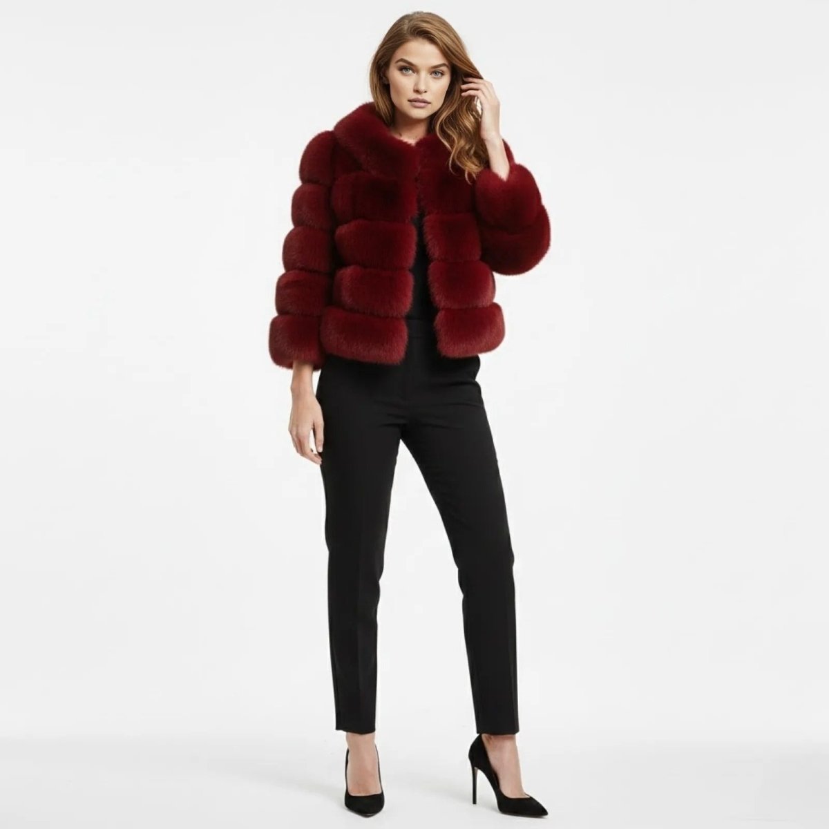 Model wearing a red cropped paneled faux fur jacket from Kouvr Fashion, paired with black trousers and heels, against a white background.