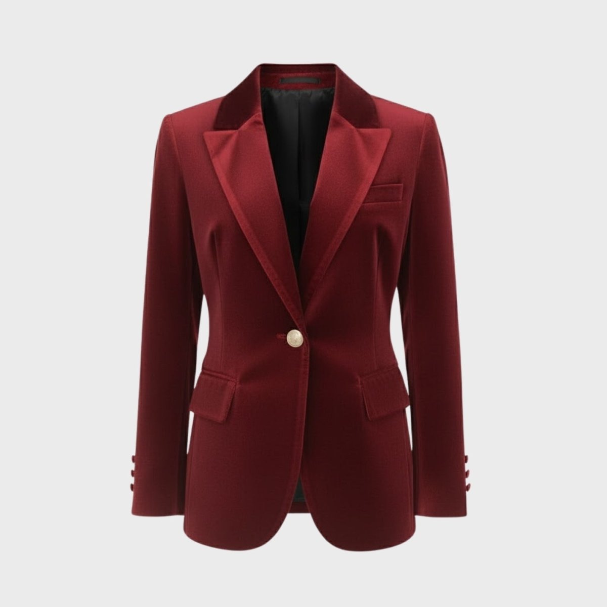 Flat lay of a single-breasted red velvet blazer showing the lapels, gold and pearl button, and rich velvet texture.