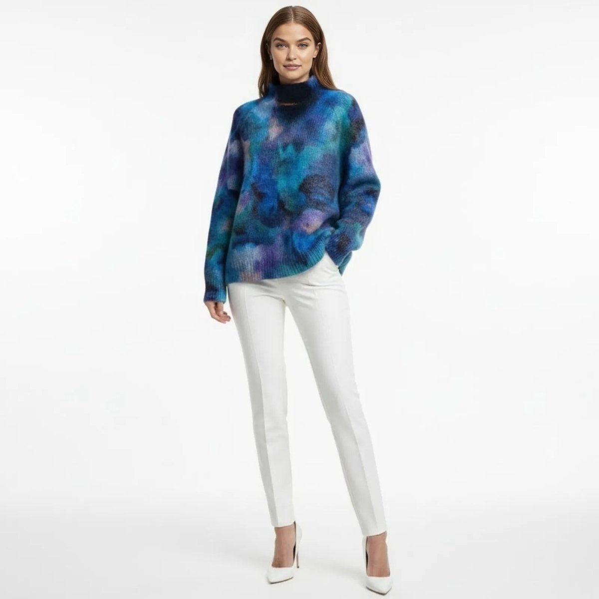 Model facing forward in the Kouvr Fashion Regina mohair turtleneck sweater, showcasing the vibrant blue, purple, and teal artistic pattern.