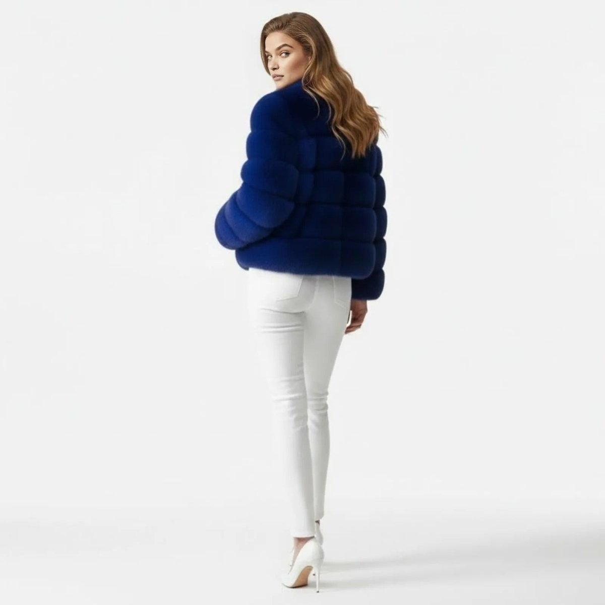 A female model showing the back of the Kouvr Fashion royal blue faux fur jacket, highlighting its horizontal panel construction.