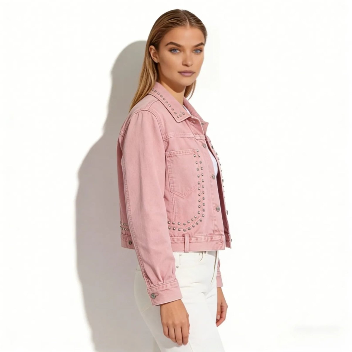 Side profile of a model wearing the Kouvr Fashion pink studded trucker jacket to show the fit and sleeve detail.