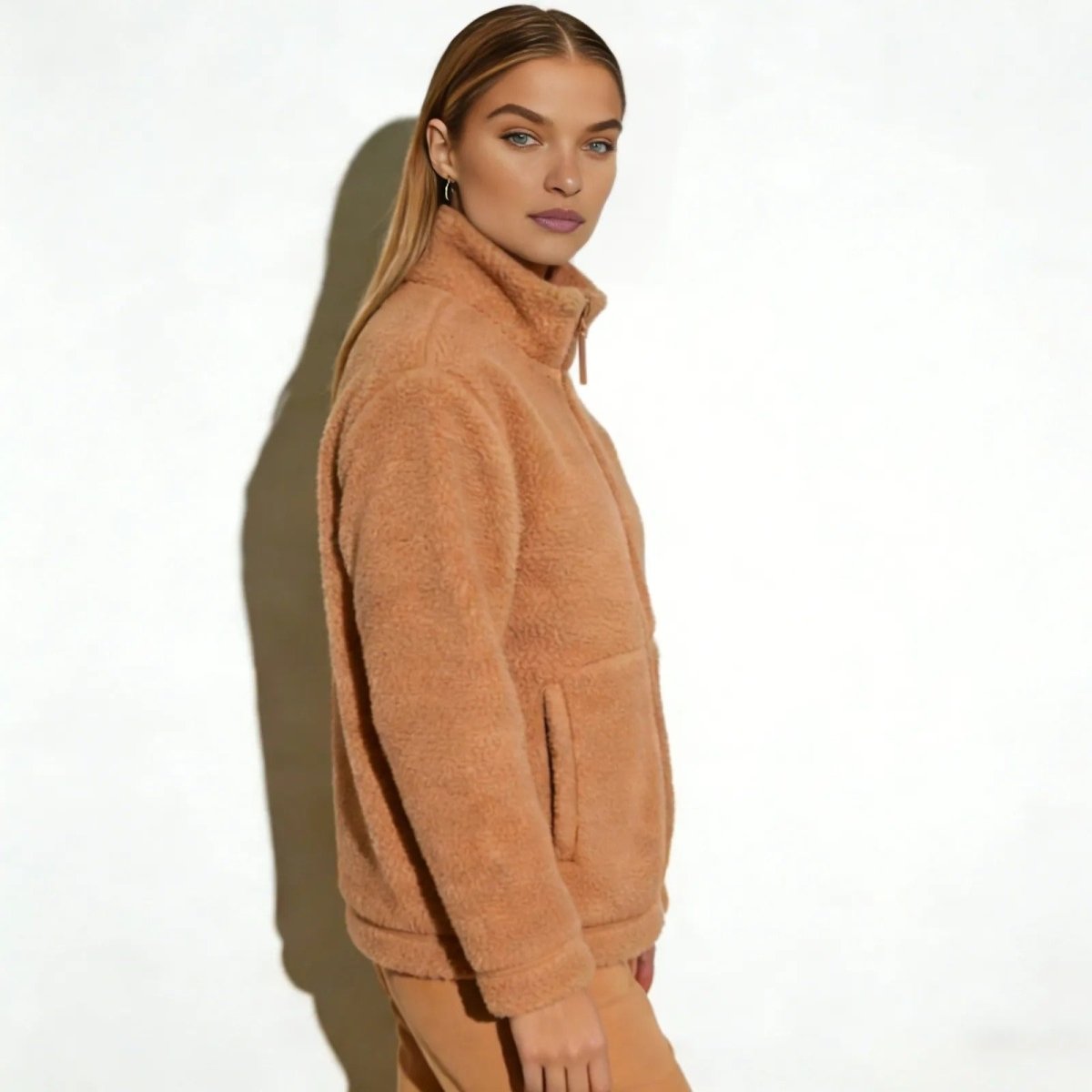 Side profile of a woman wearing the high-neck tan teddy coat from Kouvr Fashion, highlighting the jacket's silhouette and sleeve length.