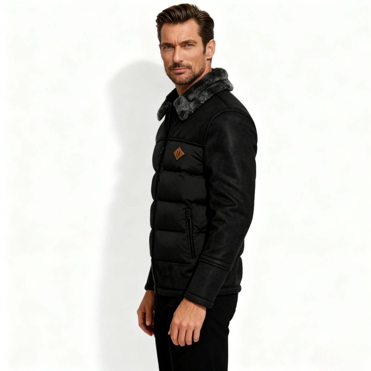 Man wearing a black Kouvr puffer jacket with a fur-lined hood on a white background