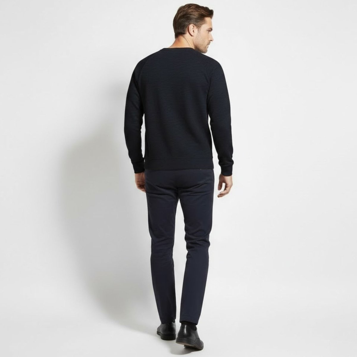 Male model from the back wearing the Kouvr Fashion Deacon navy blue sweater to show the silhouette and raglan sleeve detail.