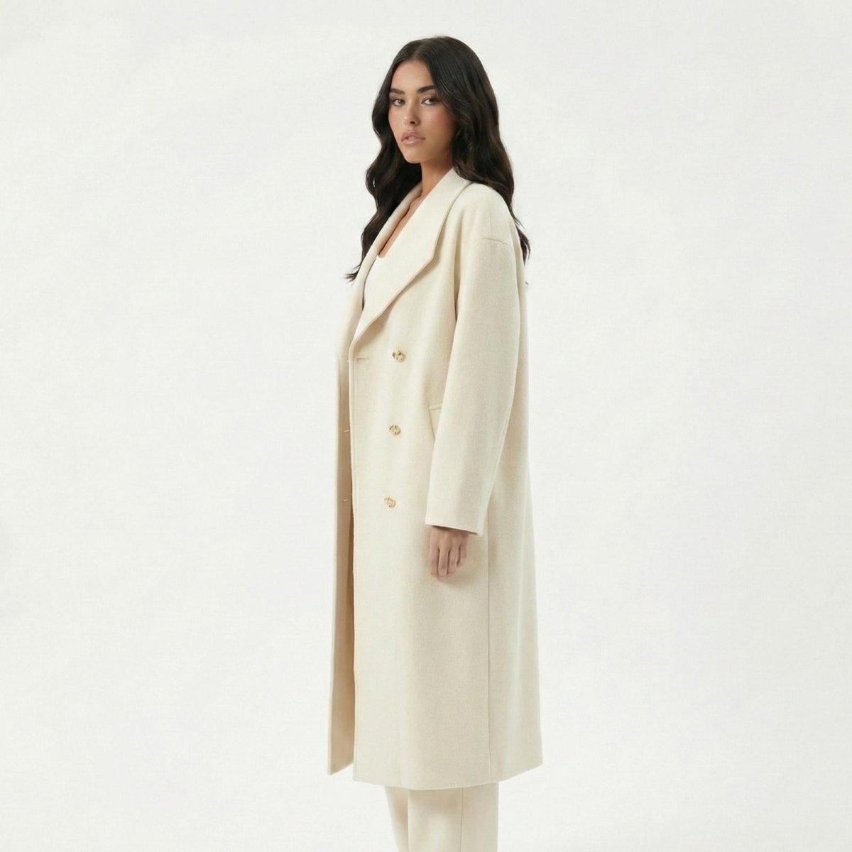 Side profile of a Madison Beer wearing the Kouvr Fashion Maddie oversized ivory wool coat, highlighting its longline cut and structured shoulders.