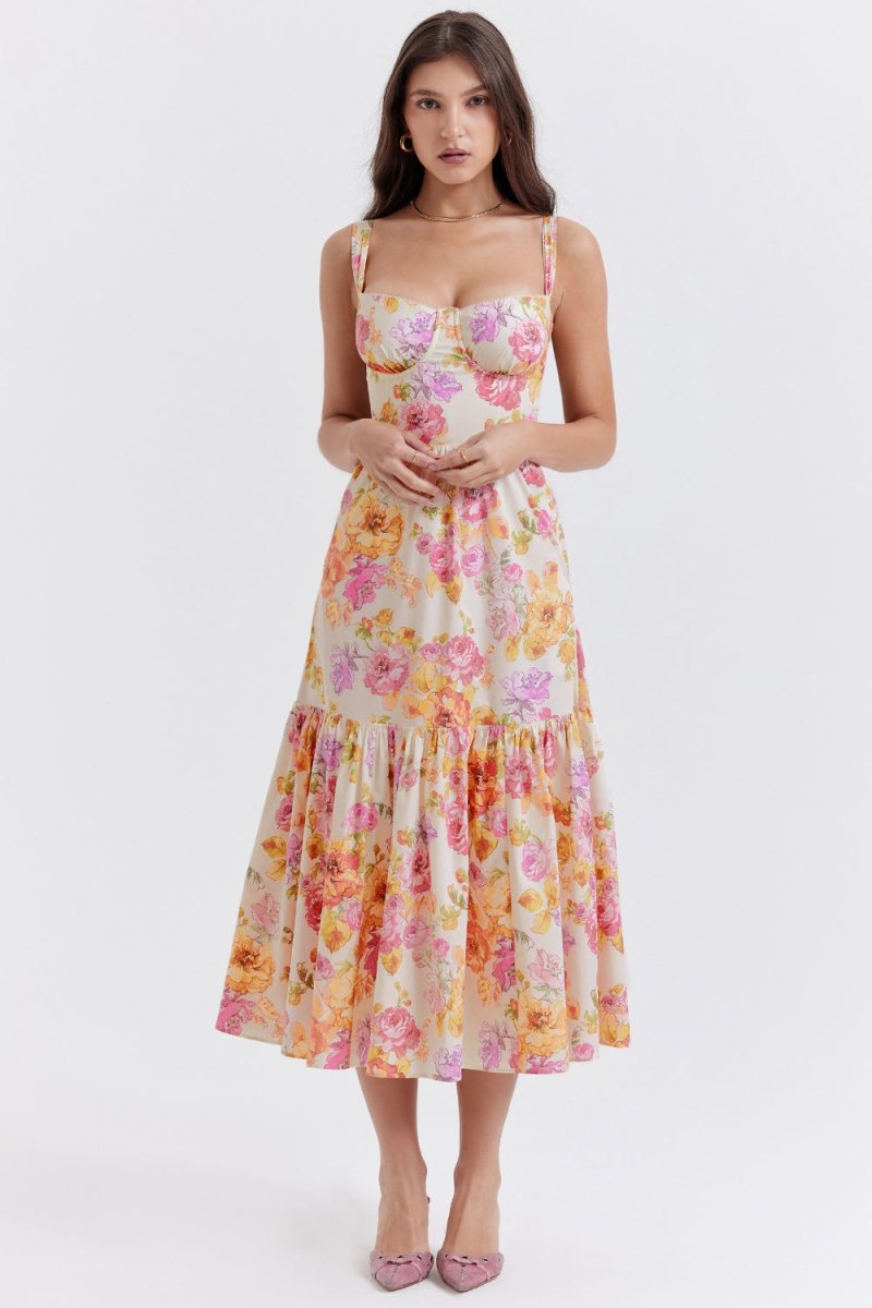 A woman wearing The Persephone floral bustier midi dress by Kouvr Fashion, featuring a sweetheart neckline and tiered skirt, against a white background.