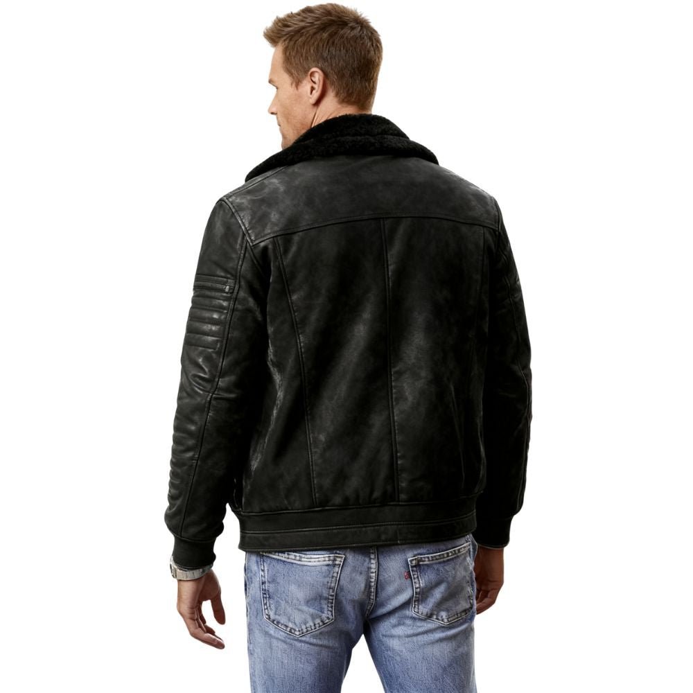 Man wearing a black kouvr leather jacket and blue jeans on a white background