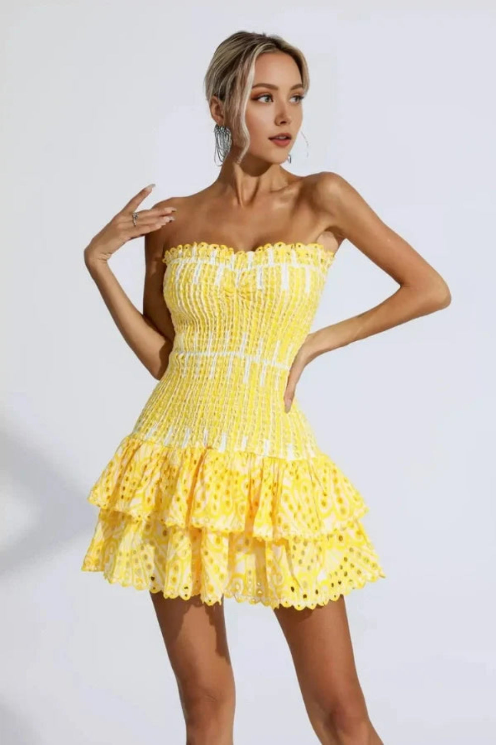 Model wearing Kouvr Fashion strapless yellow eyelet mini dress with tiered ruffle skirt