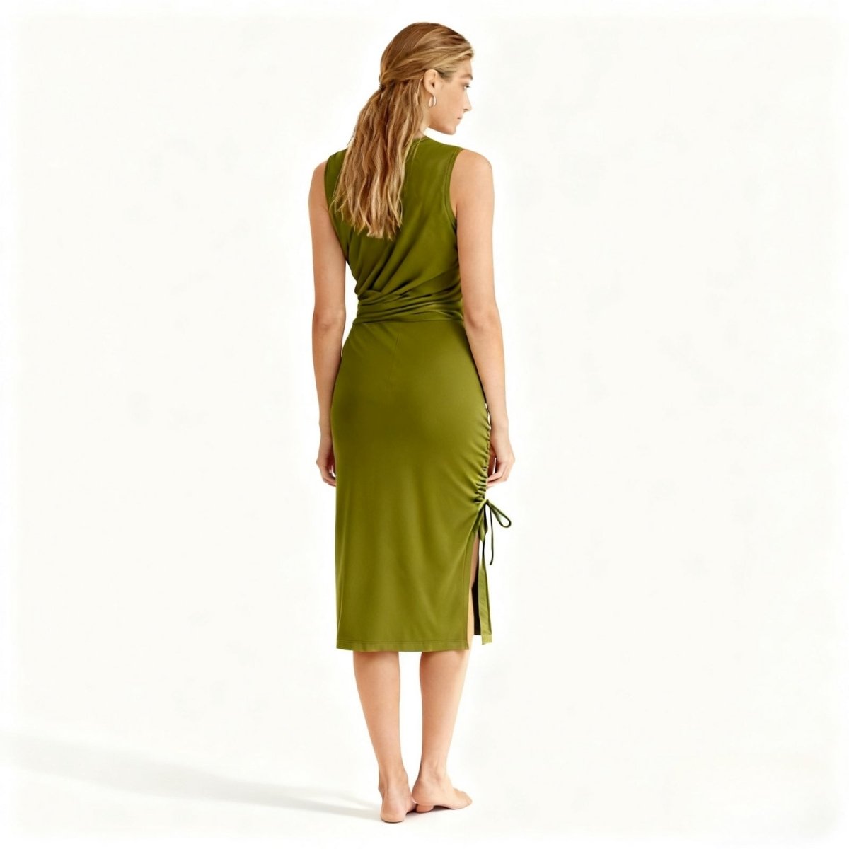 Woman wearing a green Kouvr dress with a white background