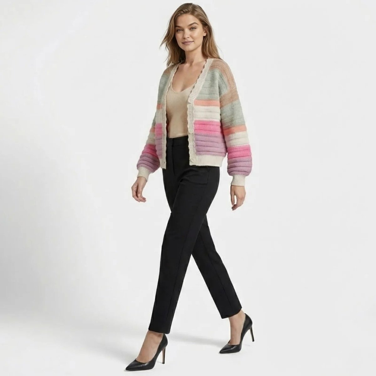 Model in a walking pose wearing the Kouvr Fern multi-color striped cardigan to show its fit and silhouette from the side.