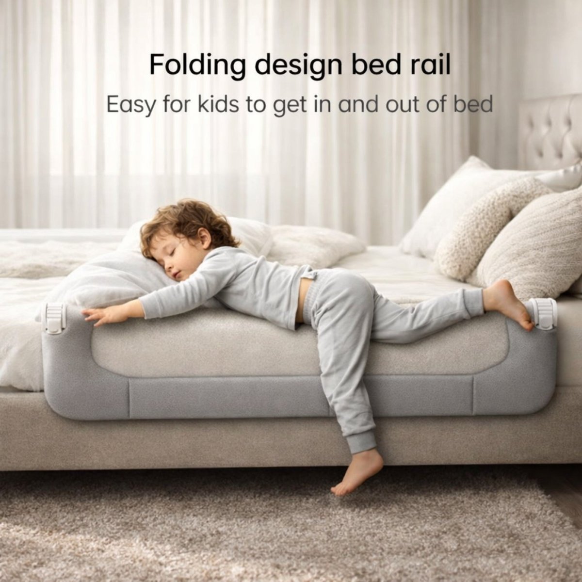 The grey Kouvr toddler bed rail in its folded-down position, demonstrating the easy access feature for a child getting in and out of bed.