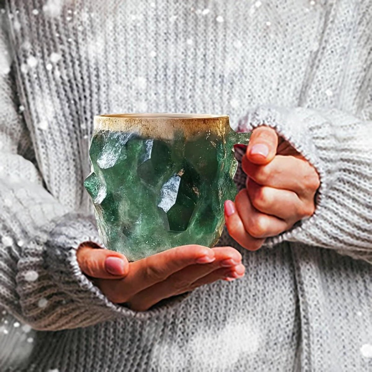 A person wearing a cozy sweater holds a unique emerald green gemstone mug, showcasing it as a perfect winter or holiday gift.