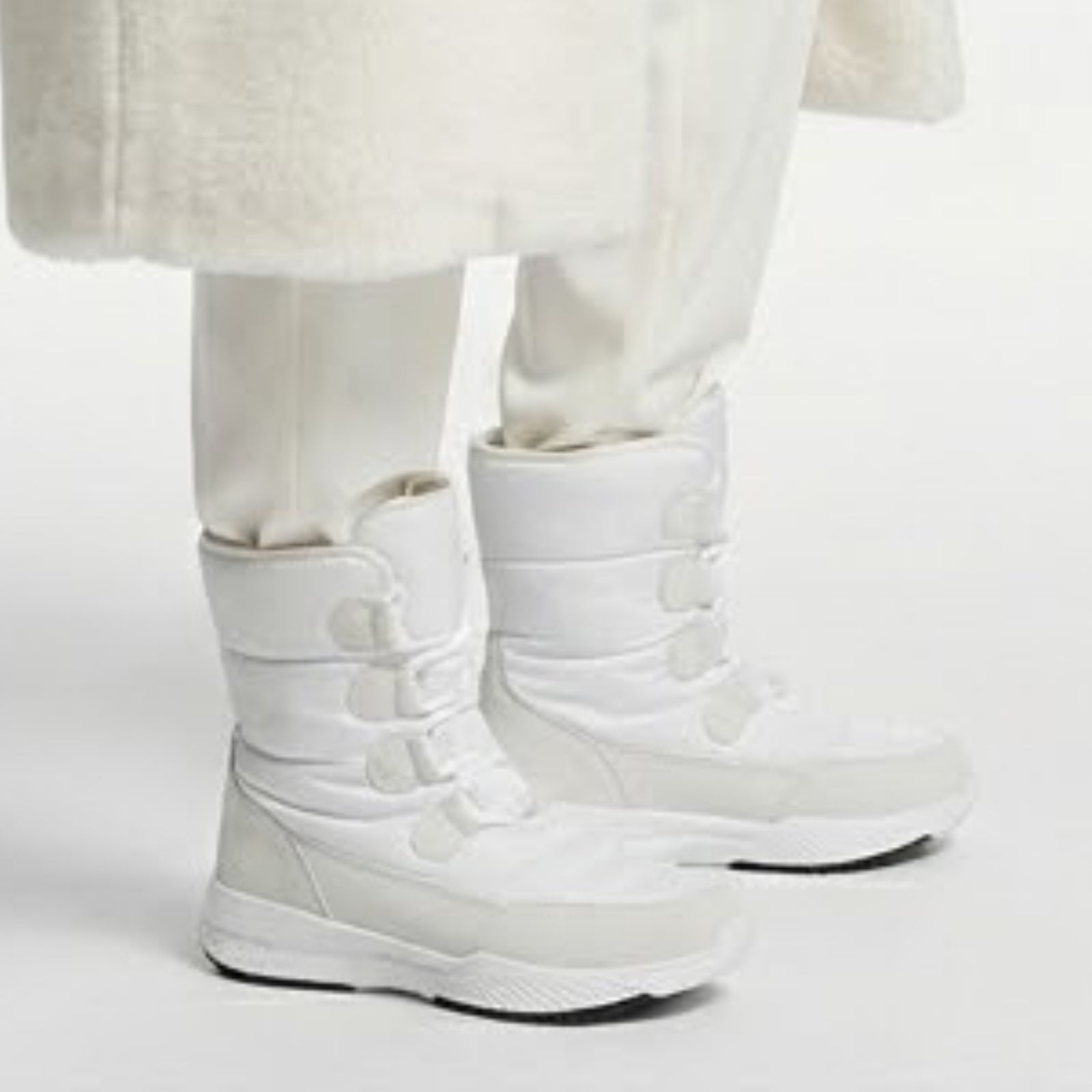 Close-up side view of the Kouvr Gianna white waterproof snow boots showing the D-ring lacing system and cushioned ankle support.