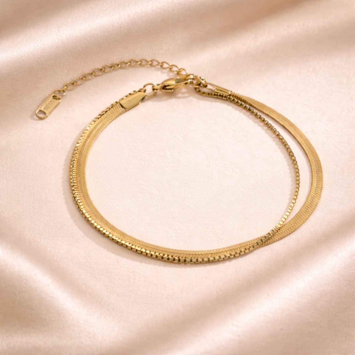 Woman wearing the Kouvr Sarielyn gold anklet while barefoot on a light wood floor, showcasing its elegant simplicity.