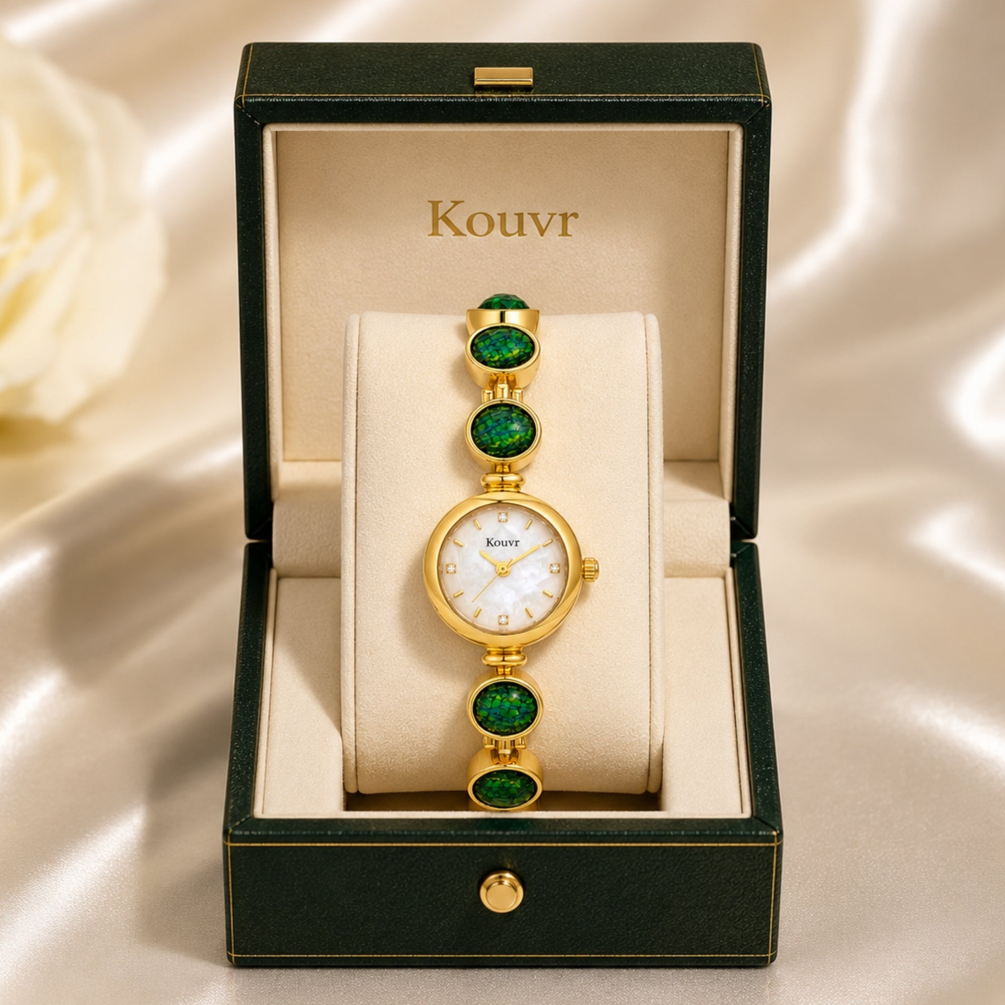 Kouvr gold vintage style women's watch with iridescent green stones displayed elegantly inside a luxury green and cream presentation box.
