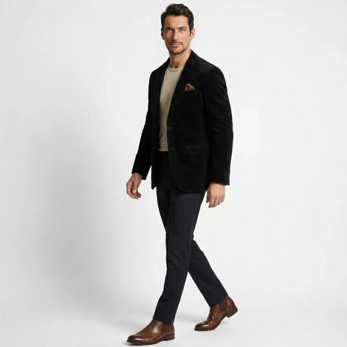 Side profile of a man walking in a black Italian corduroy sport coat from Kouvr Fashion, showing the jacket's drape and fit.