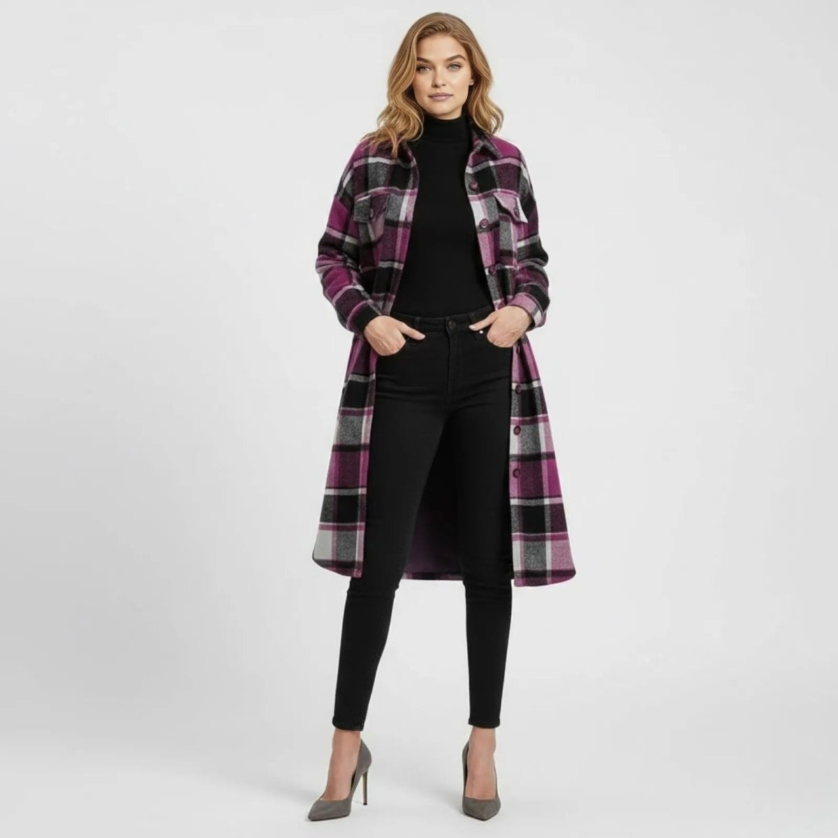 Woman wearing the Kouvr longline shacket in grey plaid, styled over a black turtleneck and skinny jeans, shown from the front.