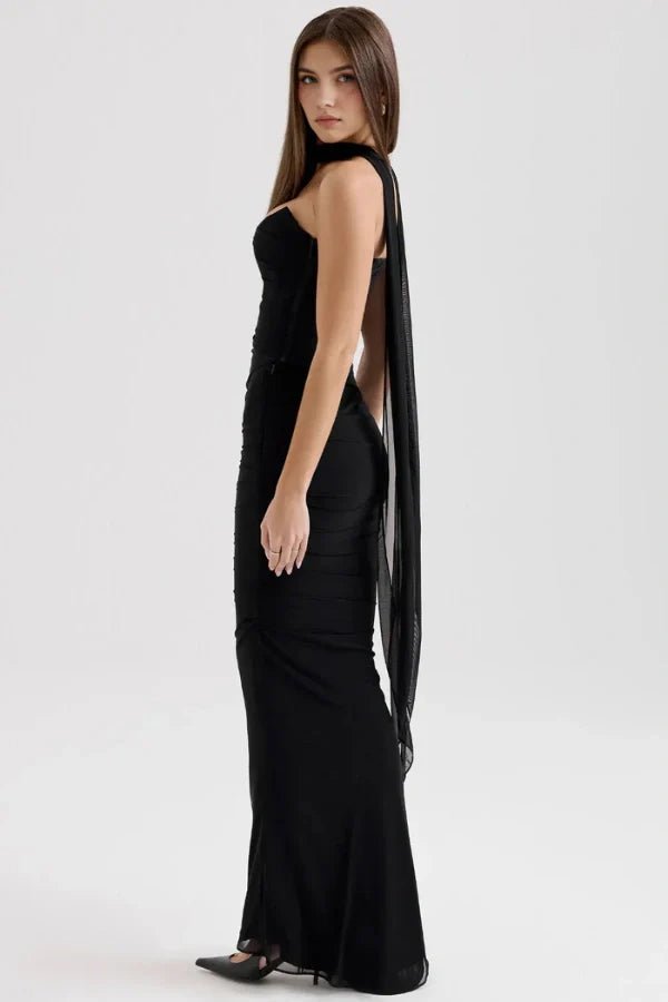 Side profile of the Kouvr Hailey black formal dress showing the fitted silhouette and an elegant, long chiffon scarf extending from the choker neckline.