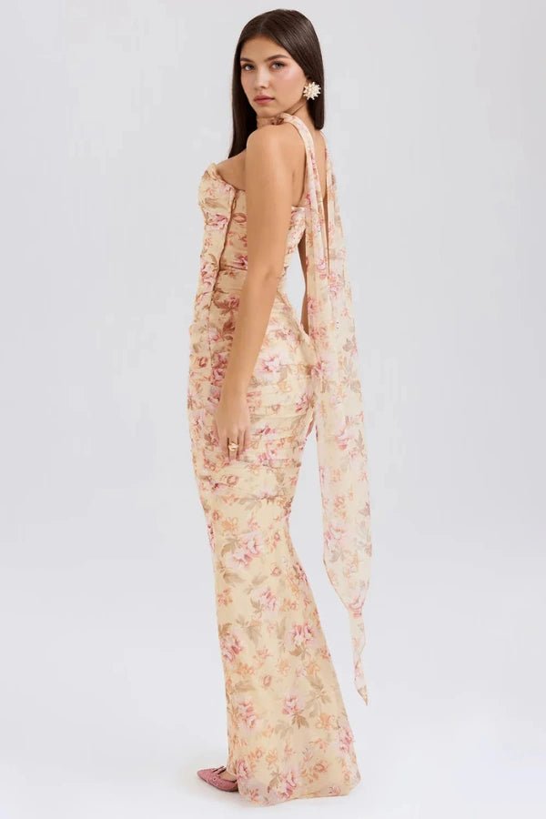 Model showing back angle of Kouvr Hailey floral strapless maxi dress, highlighting the flowing scarf detail.