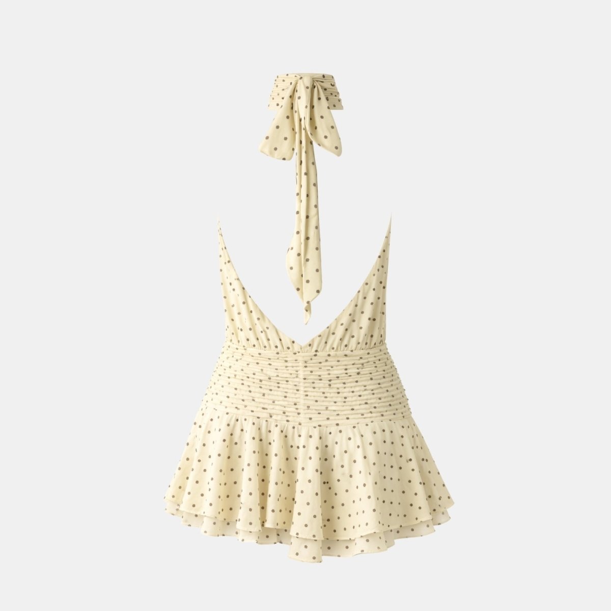 Flat lay showing the back of a beige polka dot mini dress with a deep V-back opening and a long self-tie halter strap.