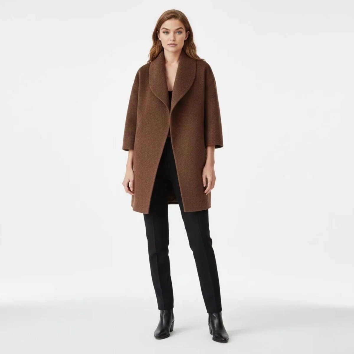 Model wearing the Kouvr Janice oversized cocoon coat in brown, styled with black pants and boots against a white background.