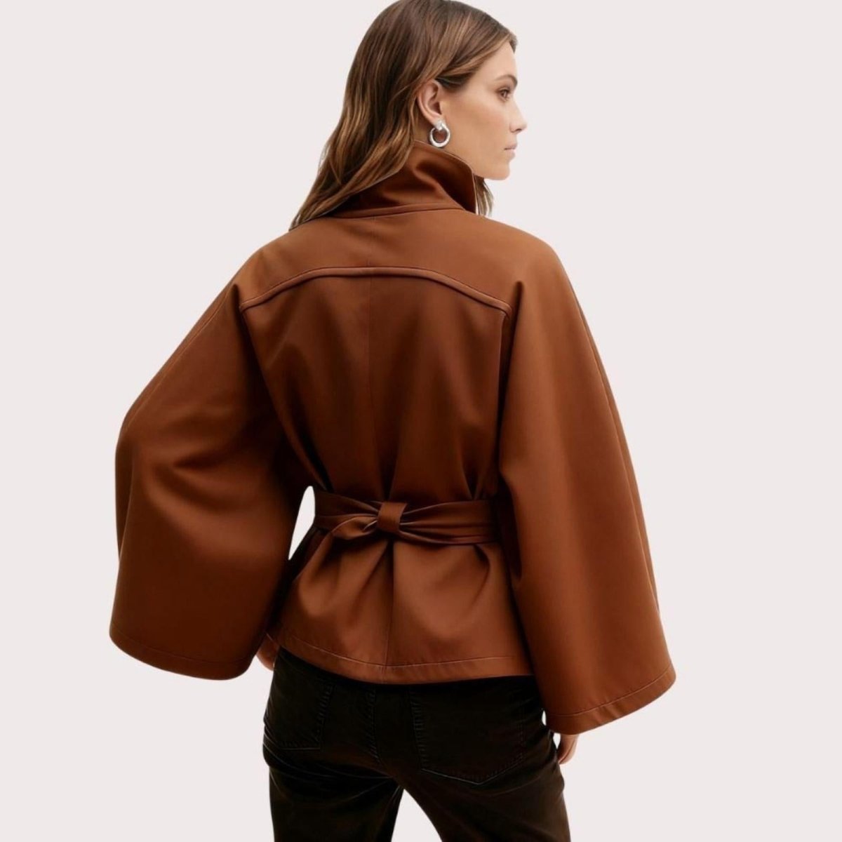 Model from the back wearing the Kouvr Jaye Belted Cape Jacket in Brown, showcasing the wide sleeves and tie-waist detail