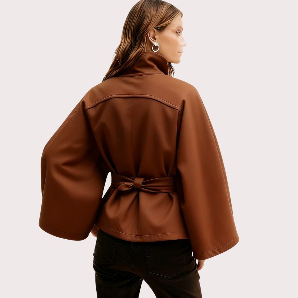 Model from the back wearing the Kouvr Jaye Belted Cape Jacket in Tobacco Brown, showcasing the wide sleeves and tie-waist detail