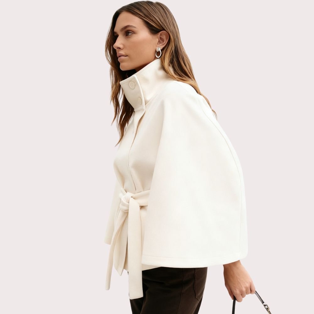 Model wearing Kouvr Fashion belted cape jacket with funnel neck and wide kimono sleeves