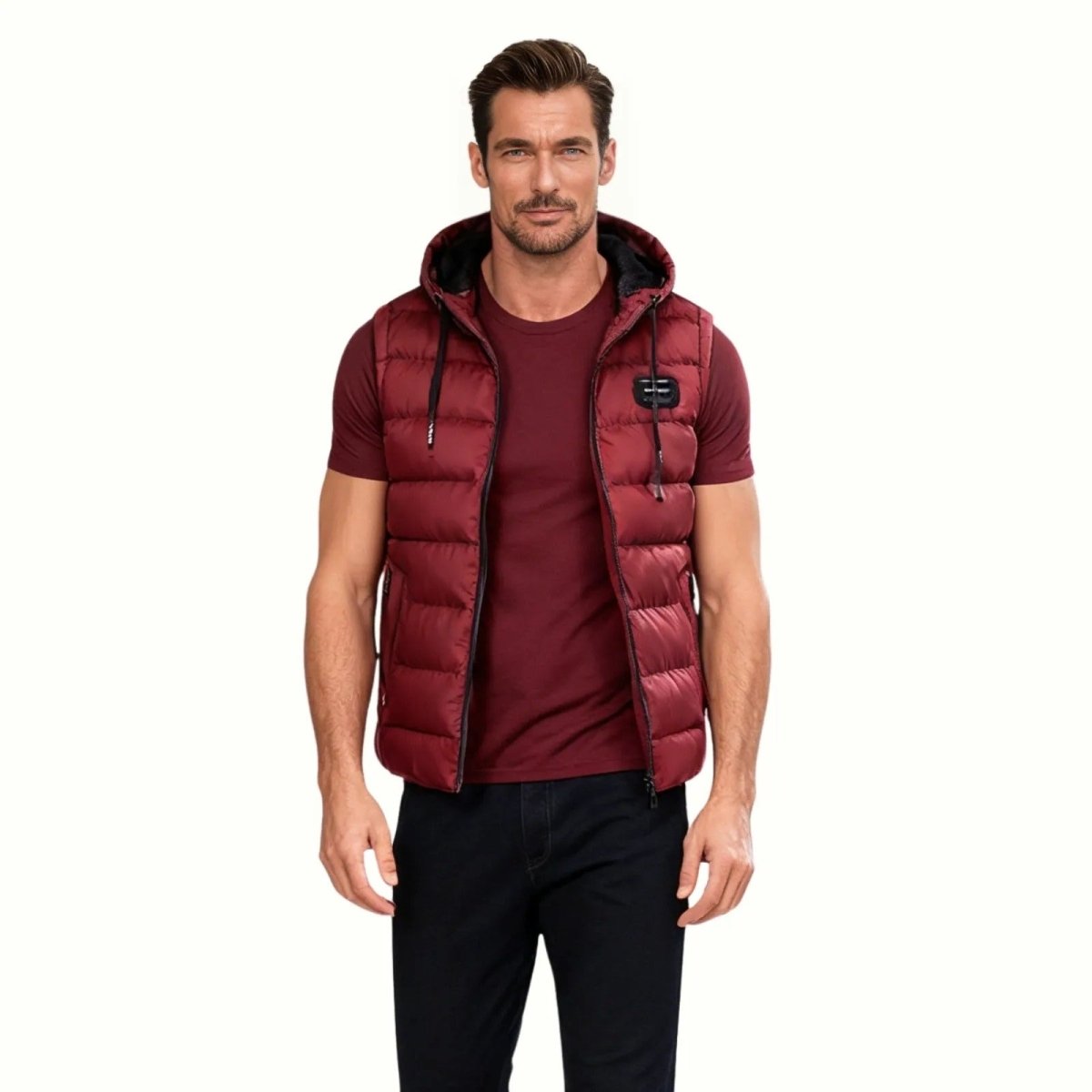 Front view of the Kouvr Jomari Men's Hooded Puffer Vest in a rich crimson red, zipped up and hanging against a dark textured wall.