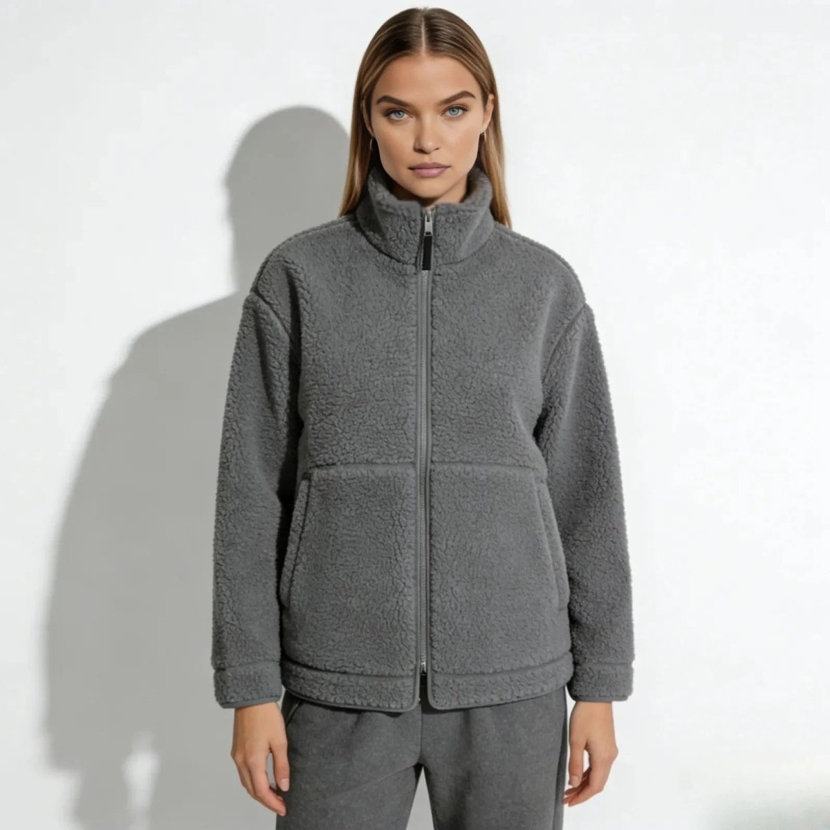 Model wearing the Kouvr Fashion Julie oversized sherpa fleece jacket gray, zipped up to the high neck, showing the front patch pockets