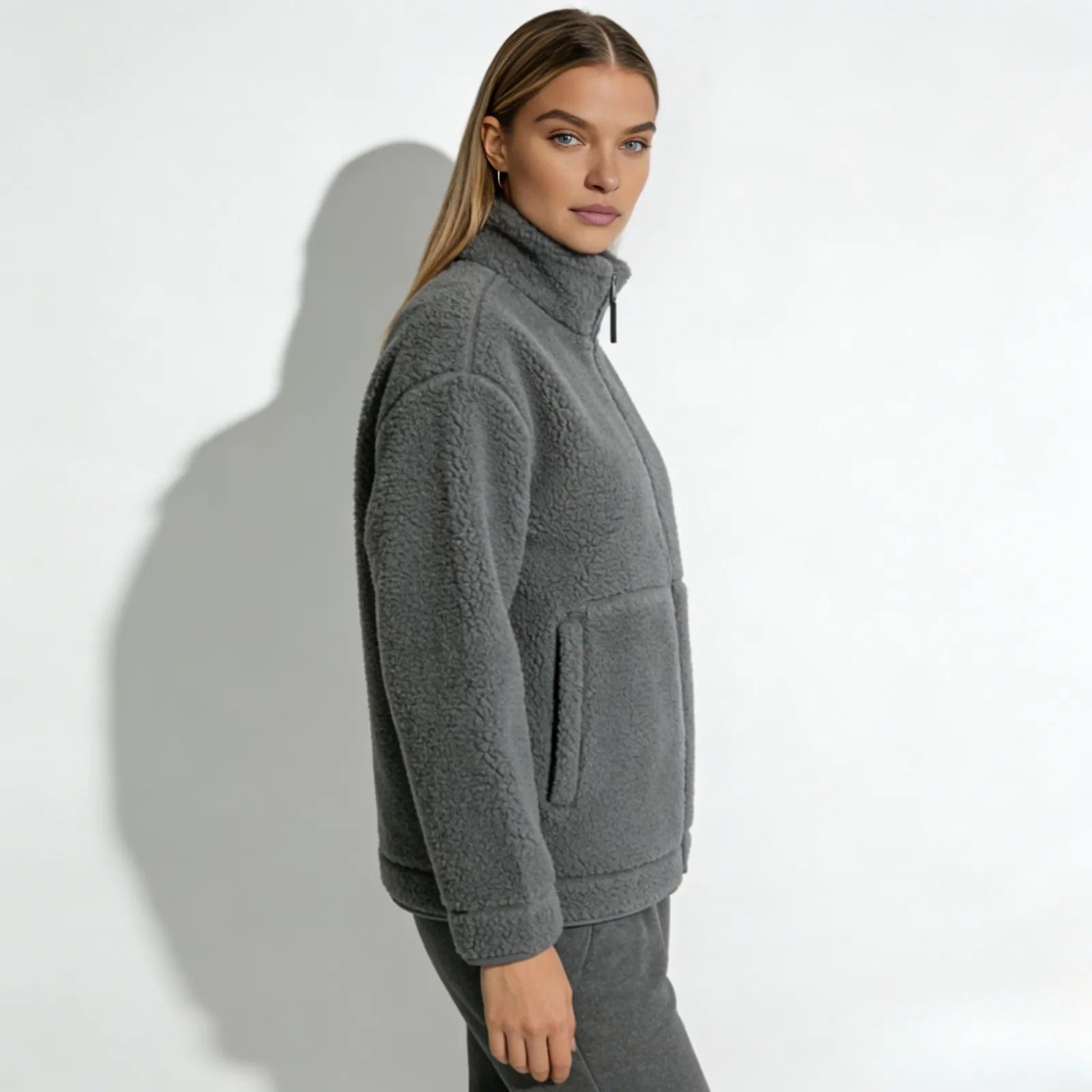 Side profile of a woman wearing the gray Julie sherpa jacket by Kouvr Fashion, highlighting its relaxed fit and sleeve length.