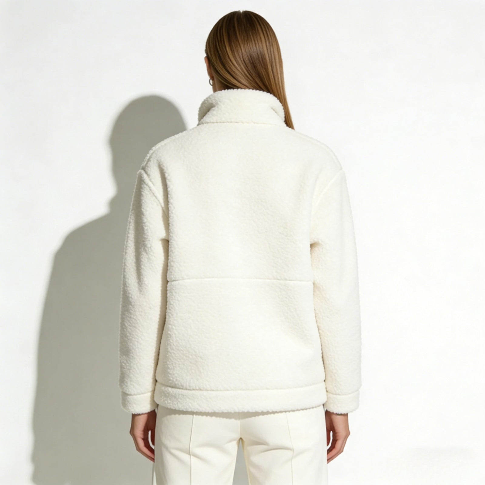 Rear view of a model wearing the Kouvr Julie full-zip fleece jacket, highlighting the back paneling detail.