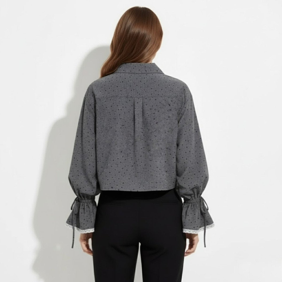 Back view of a model in the Kouvr Kara gray blouse, showing the back yoke detail and the drape of the voluminous sleeves.
