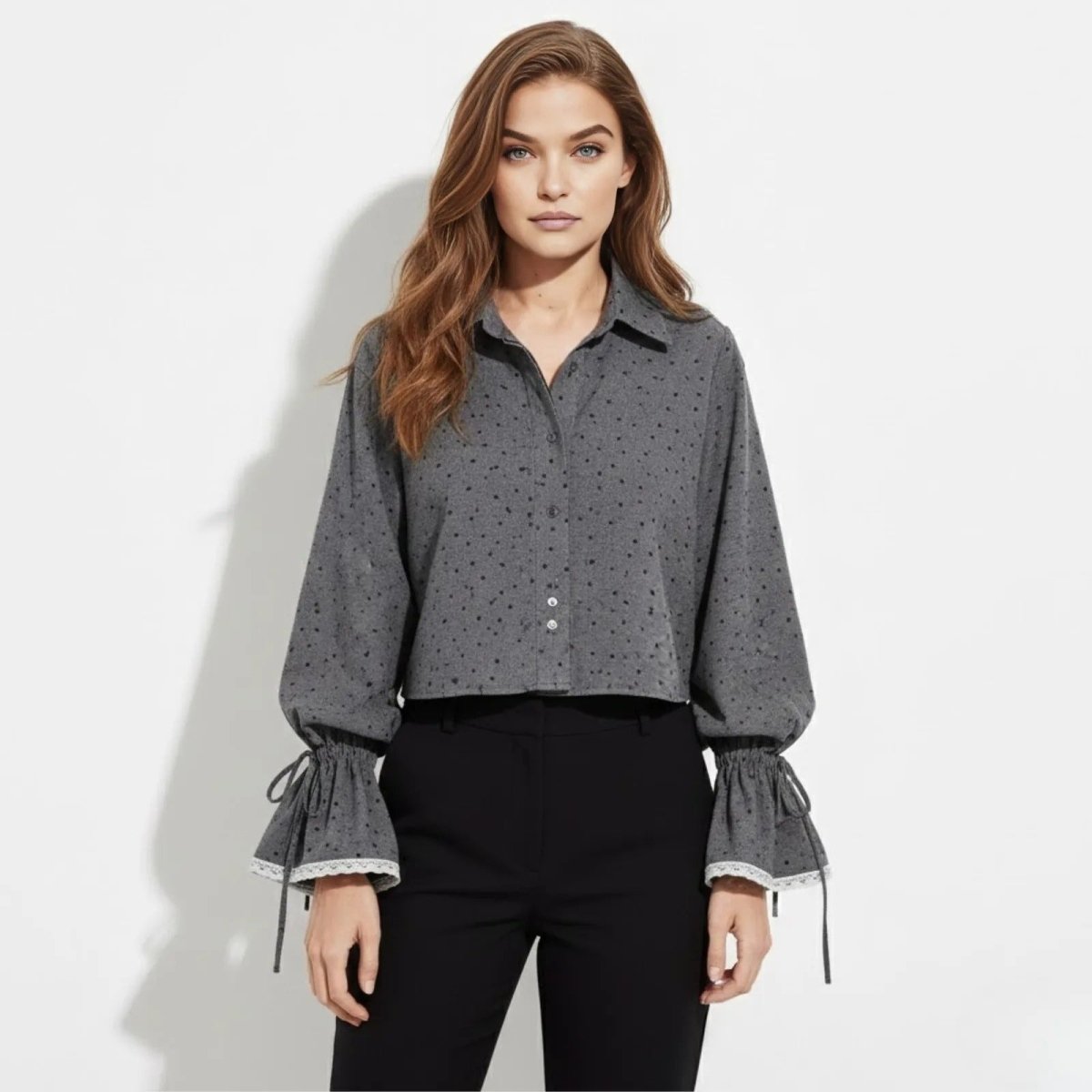 Model wearing the Kouvr Kara gray dotted cropped blouse with voluminous balloon sleeves and lace tie cuffs, shown from the front against a white background.