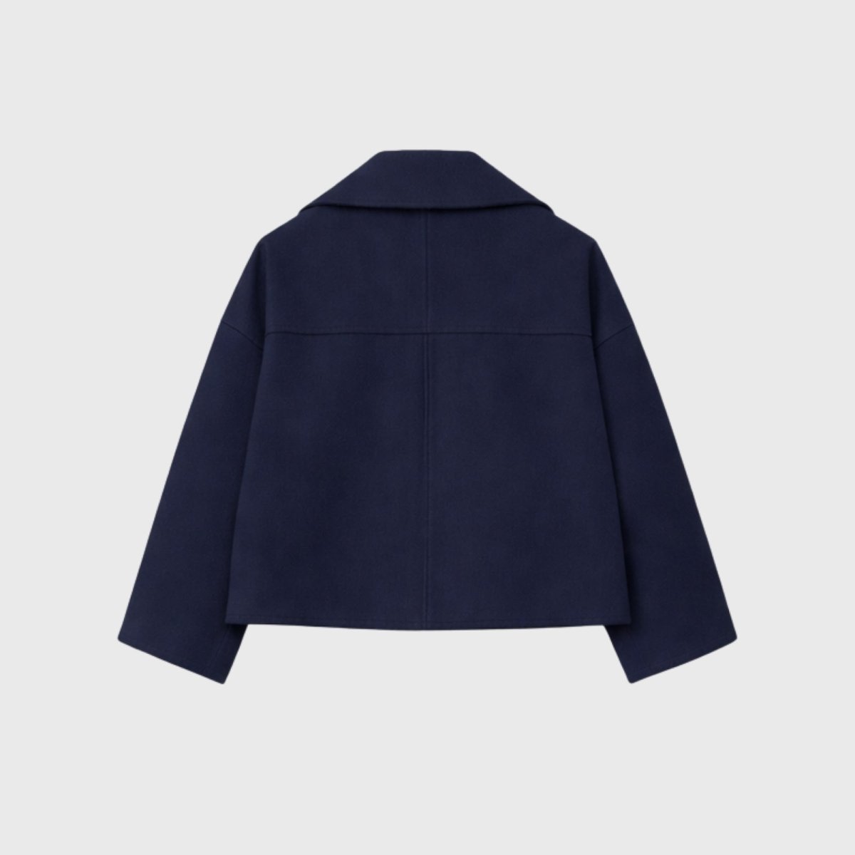 Studio flatlay of the back of the Kouvr Katherine navy peacoat, showing the precision tailoring and rich texture of the Italian wool.