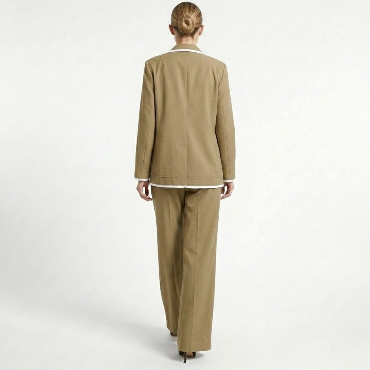 Back view of a model wearing the Kouvr khaki blazer and trousers set, highlighting the suit's clean lines and relaxed tailoring.