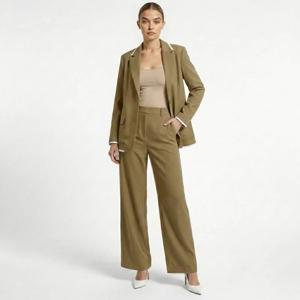 Model facing forward wearing the Kouvr khaki relaxed fit suit set, featuring a single-breasted blazer and wide-leg trousers with white contrast piping.