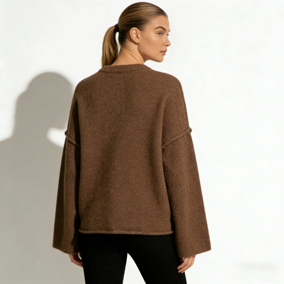 Back view of the Kouvr Krystal oversized knit sweater, highlighting its boxy silhouette and clean lines in a warm brown hue.