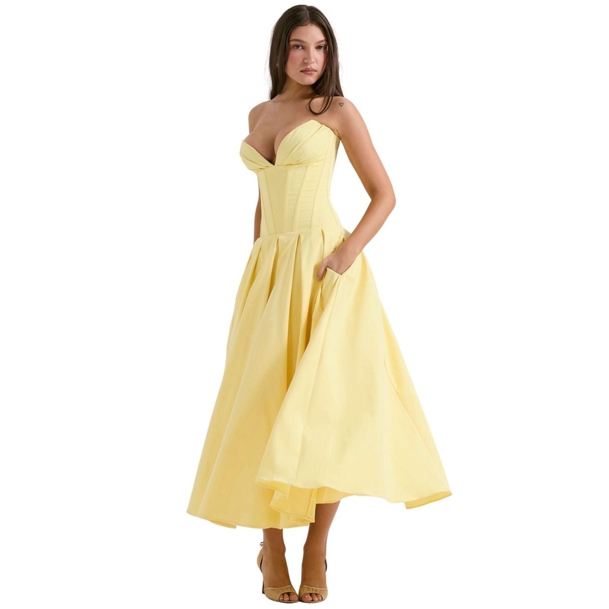 Woman wearing a yellow strapless dress on a white background