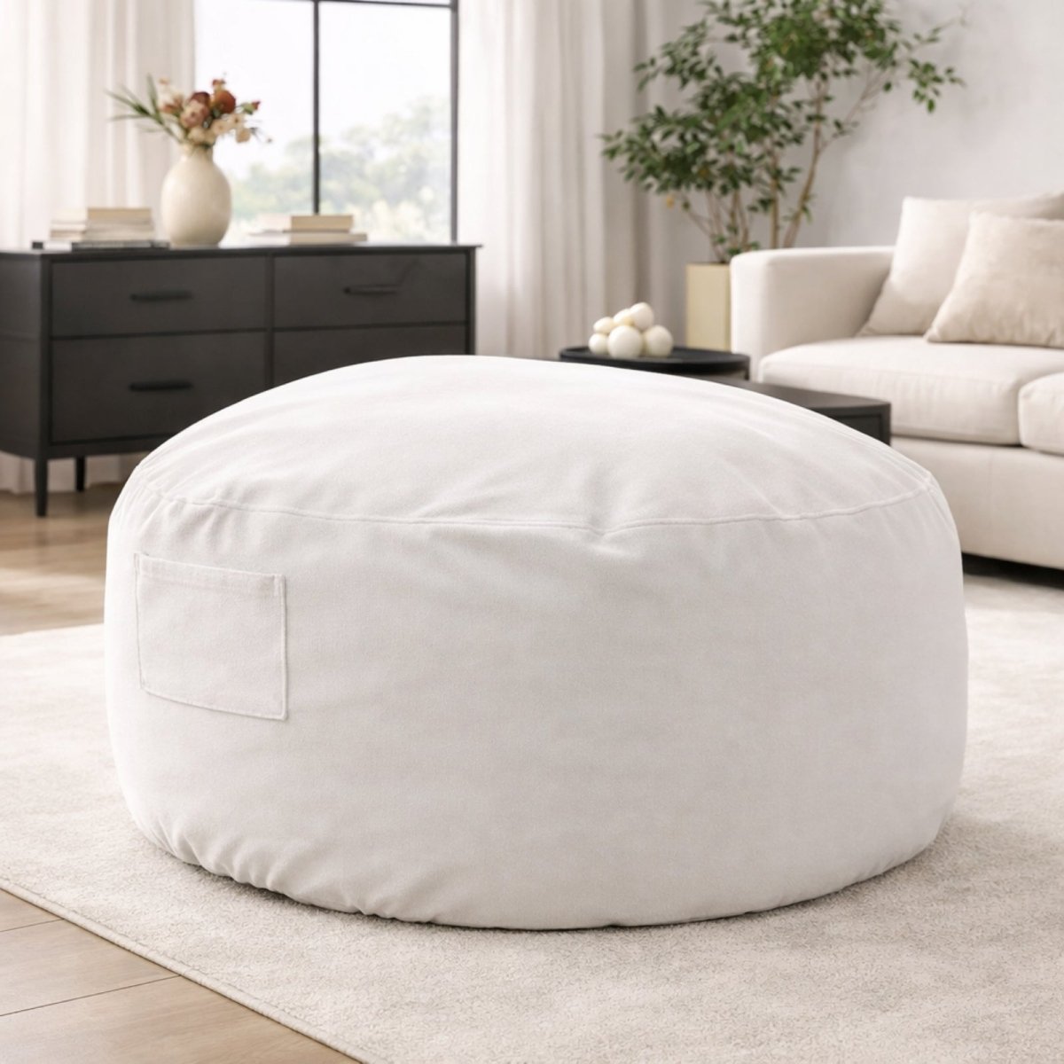 Large dark grey memory foam bean bag chair by Kouvr, shown in a modern living room with a black console table in the background.