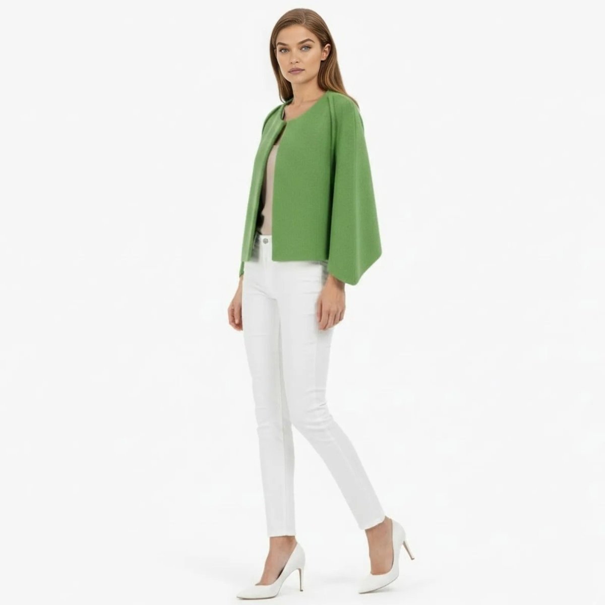 Model in a side profile pose wearing the Kouvr Laverne green cape jacket, showcasing the sleeve silhouette and structured fit.